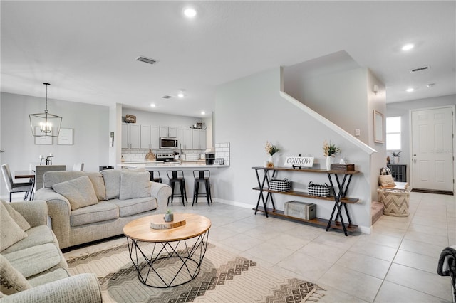 living room with light tile patterned floors and a chandelier