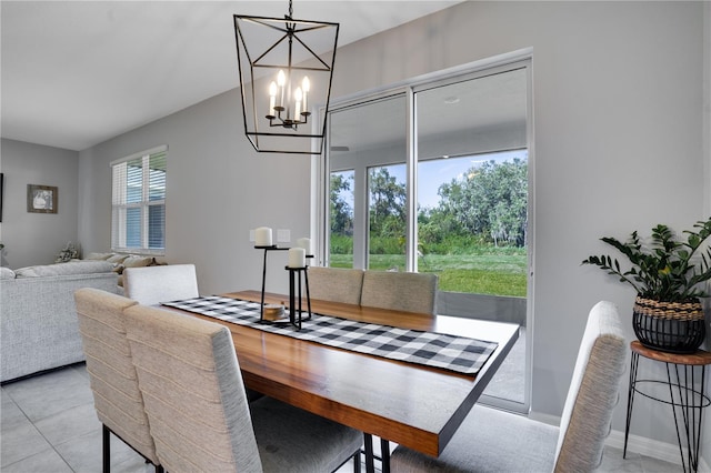 tiled dining room with a chandelier