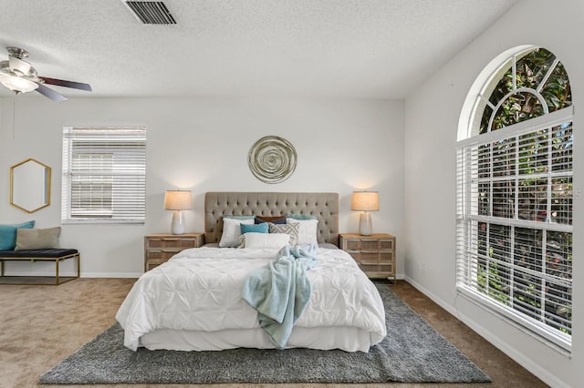 carpeted bedroom with a textured ceiling and ceiling fan