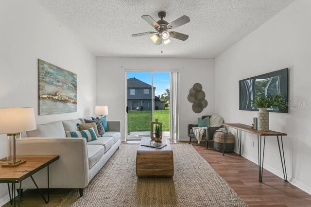 living room with ceiling fan, hardwood / wood-style floors, and a textured ceiling