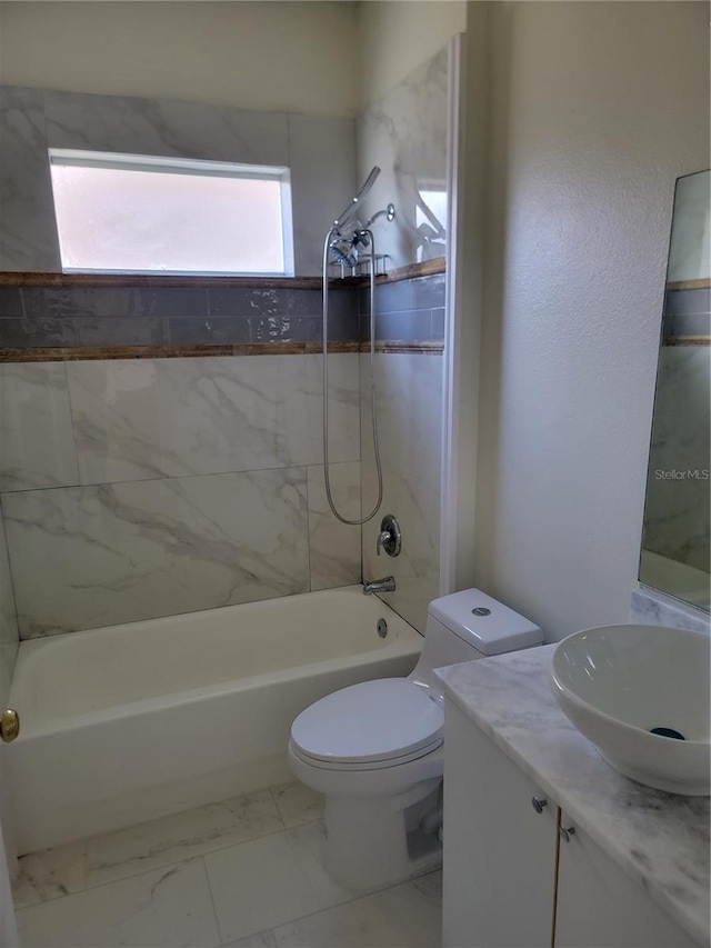 full bathroom featuring vanity, tiled shower / bath combo, and toilet