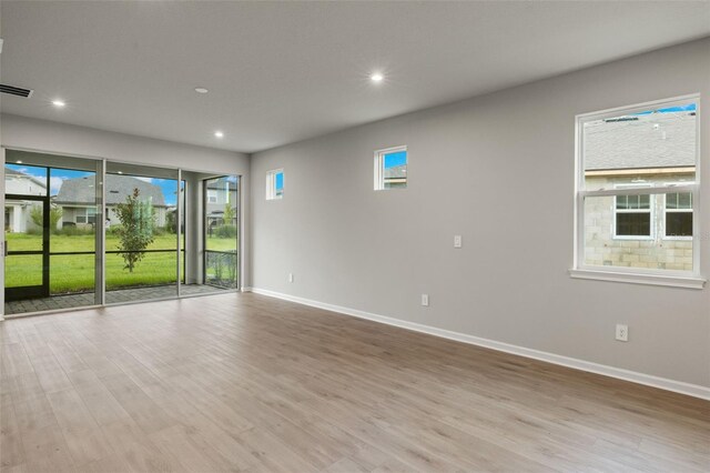 unfurnished room with light hardwood / wood-style floors and a healthy amount of sunlight