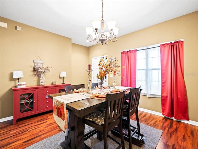 dining area with a notable chandelier and wood-type flooring