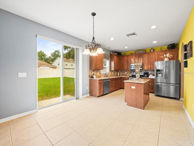 kitchen with backsplash, stainless steel appliances, light tile patterned floors, a center island, and hanging light fixtures