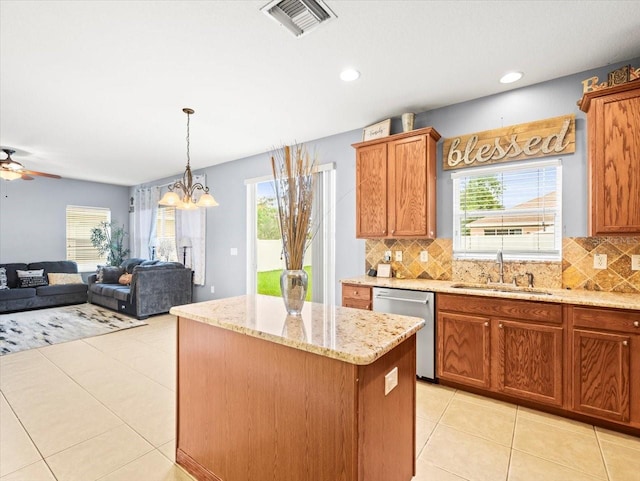 kitchen with sink, plenty of natural light, light tile patterned floors, and a kitchen island