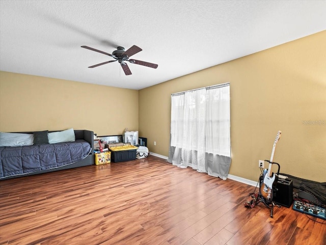 interior space featuring a textured ceiling, ceiling fan, and wood-type flooring