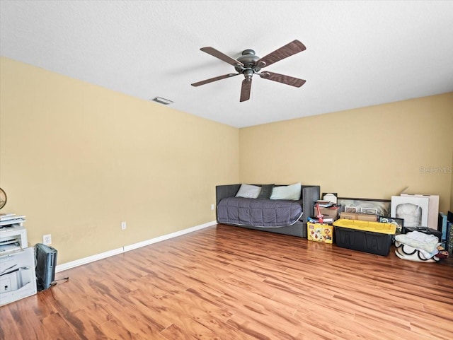 living area with ceiling fan and hardwood / wood-style flooring