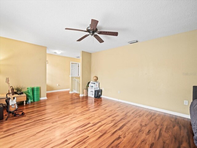 interior space featuring a textured ceiling, ceiling fan, and light wood-type flooring