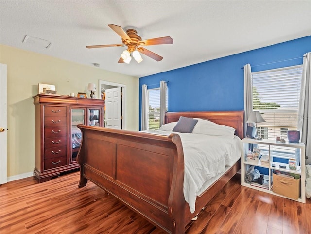 bedroom featuring hardwood / wood-style flooring, multiple windows, and ceiling fan