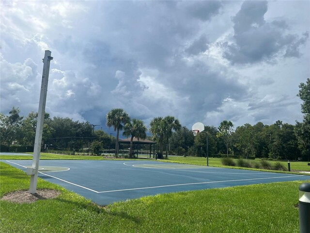 view of sport court with a lawn