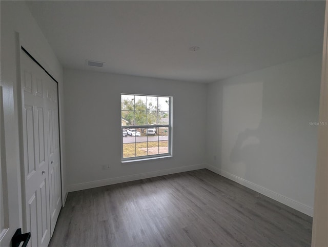 unfurnished bedroom with hardwood / wood-style flooring and a closet