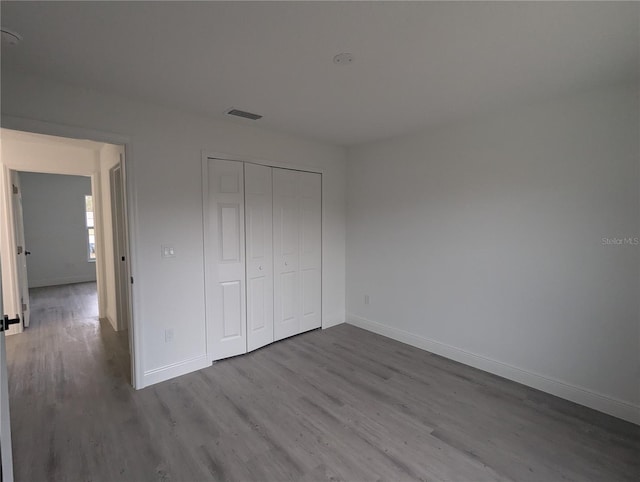 unfurnished bedroom featuring hardwood / wood-style floors and a closet