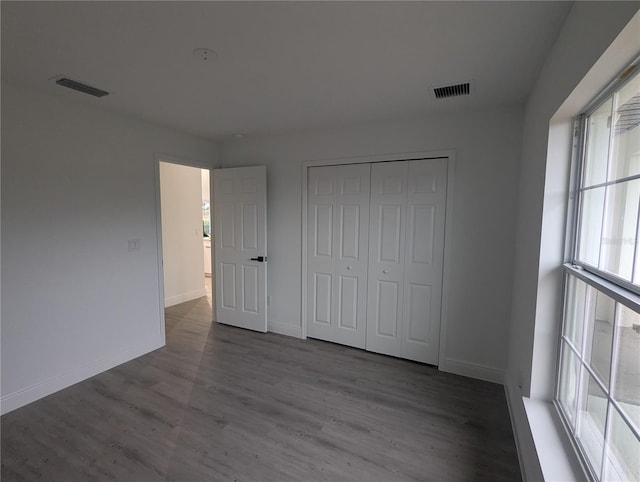 unfurnished bedroom with wood-type flooring and a closet