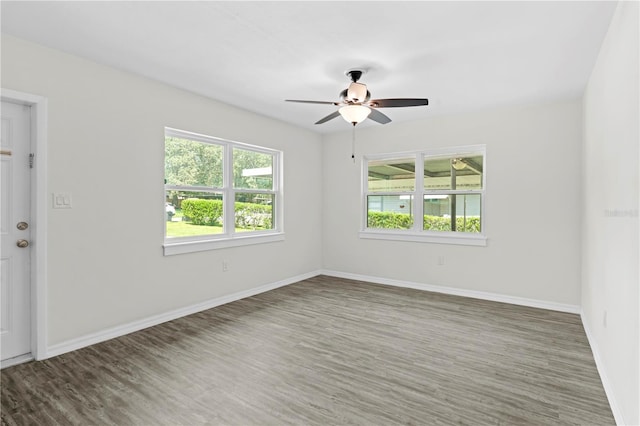 spare room with dark wood-type flooring and baseboards