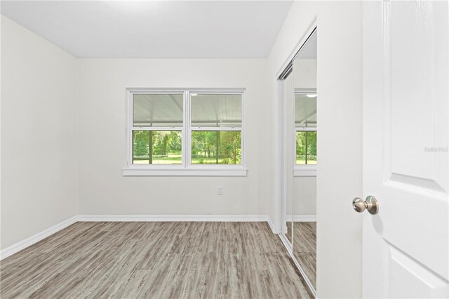 unfurnished room with a wealth of natural light and hardwood / wood-style floors