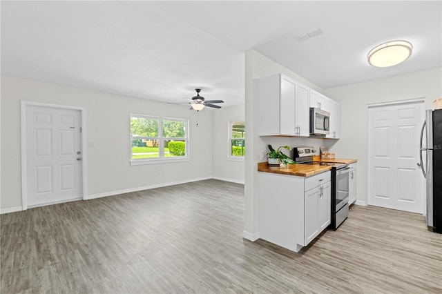 kitchen with ceiling fan, light wood-type flooring, white cabinets, and stainless steel appliances