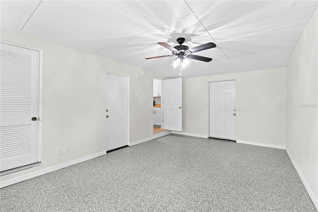 unfurnished room with ceiling fan, baseboards, and speckled floor