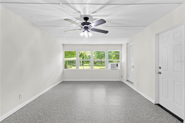 unfurnished room featuring speckled floor, cooling unit, a ceiling fan, and baseboards