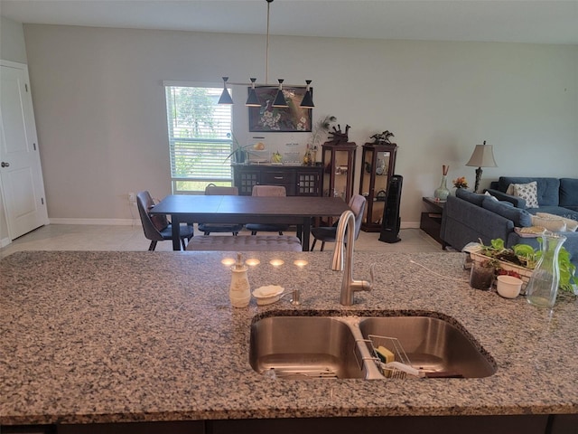 kitchen with light stone counters, sink, and light tile patterned floors