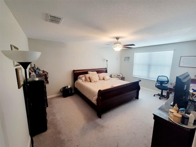 carpeted bedroom with ceiling fan and a textured ceiling