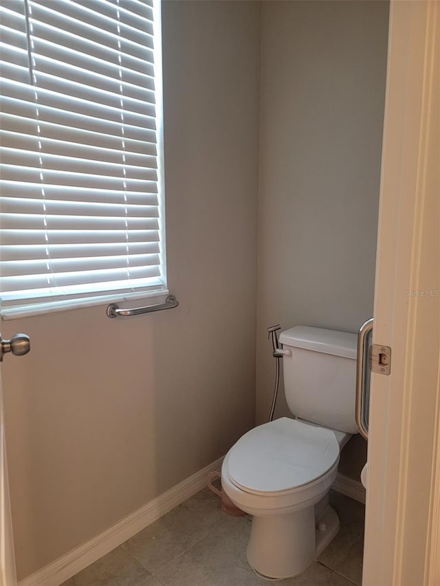 bathroom featuring toilet and tile patterned flooring