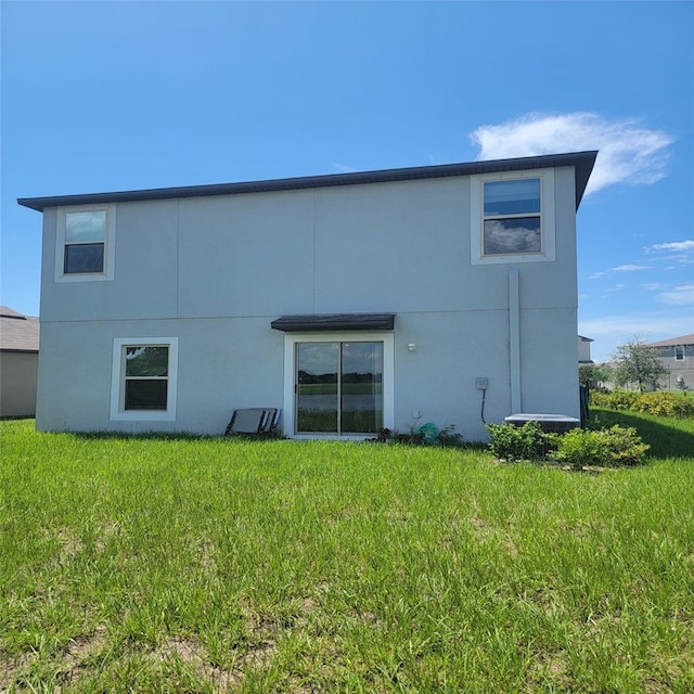 14443 Touch Gold Ln, Sun City Center, FL 33573 - rear view of property featuring stucco siding and a lawn