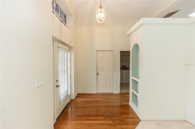 hall with wood-type flooring and ornamental molding