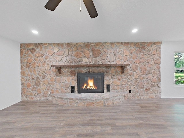 details featuring ceiling fan, a fireplace, and wood-type flooring