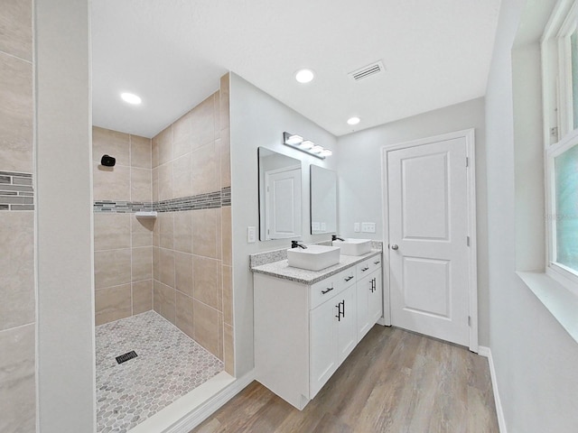 bathroom with vanity, tiled shower, and hardwood / wood-style floors