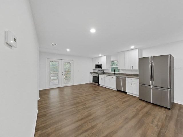 kitchen with stainless steel appliances, wood-type flooring, white cabinets, and french doors