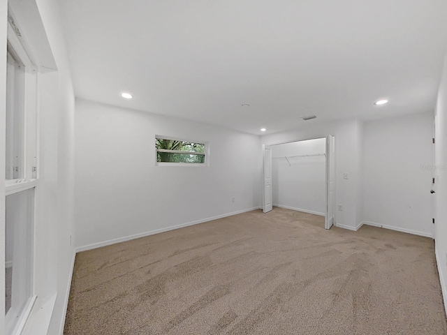 spare room featuring light colored carpet