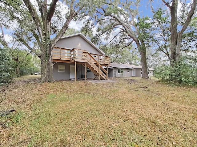 back of property featuring a deck and a lawn