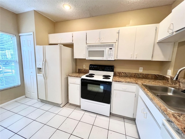 kitchen with white cabinetry, sink, a textured ceiling, light tile patterned floors, and white appliances