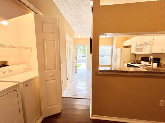 interior space featuring light wood-type flooring, washer and clothes dryer, and a textured ceiling