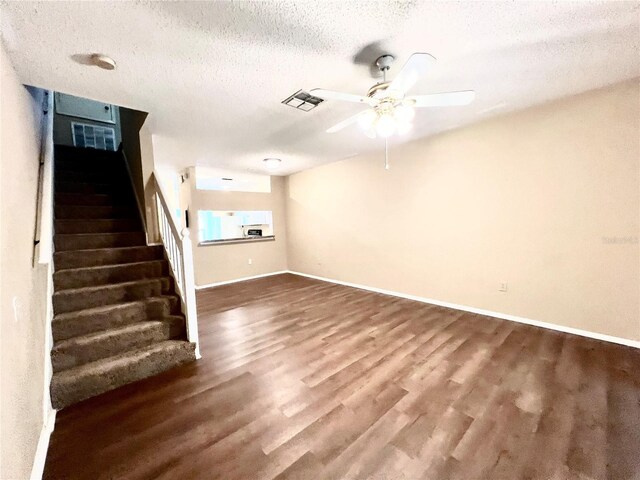 unfurnished living room featuring a textured ceiling, ceiling fan, and hardwood / wood-style flooring