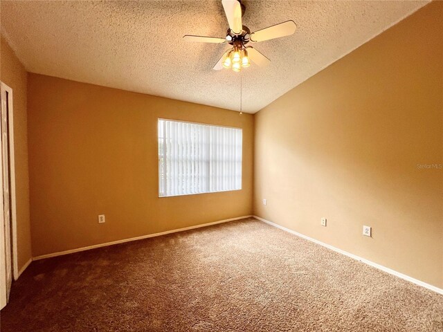 carpeted empty room with ceiling fan and a textured ceiling