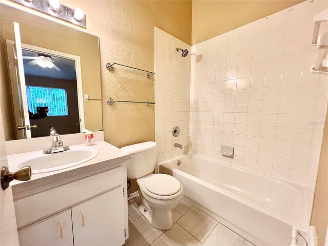 full bathroom with tile patterned flooring, toilet, tiled shower / bath, and vanity