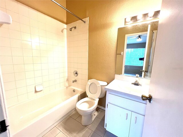 full bathroom featuring tiled shower / bath, toilet, tile patterned floors, and vanity