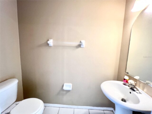 bathroom featuring sink, toilet, and tile patterned flooring