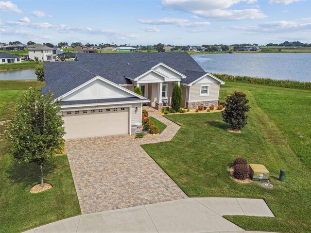 ranch-style house featuring a water view, a garage, and a front yard