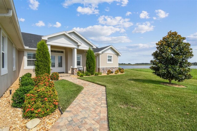 view of front of house featuring a front lawn and a water view