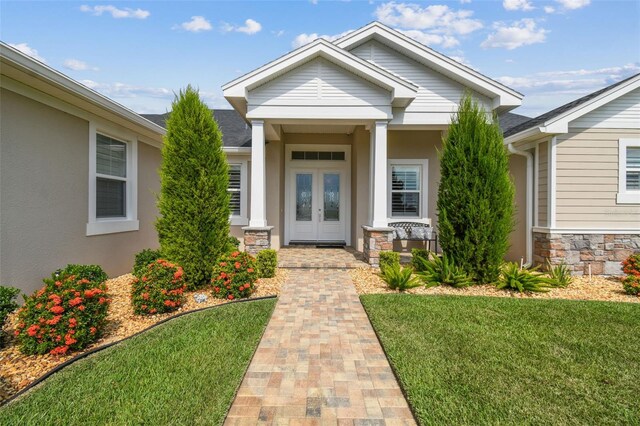 view of exterior entry featuring a lawn