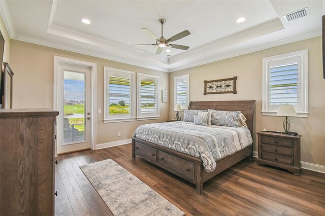 bedroom featuring ceiling fan, a raised ceiling, dark hardwood / wood-style flooring, and access to exterior