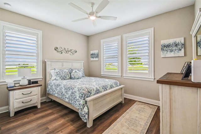 bedroom with multiple windows, dark wood-type flooring, and ceiling fan