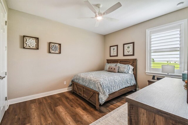 bedroom with dark hardwood / wood-style flooring and ceiling fan