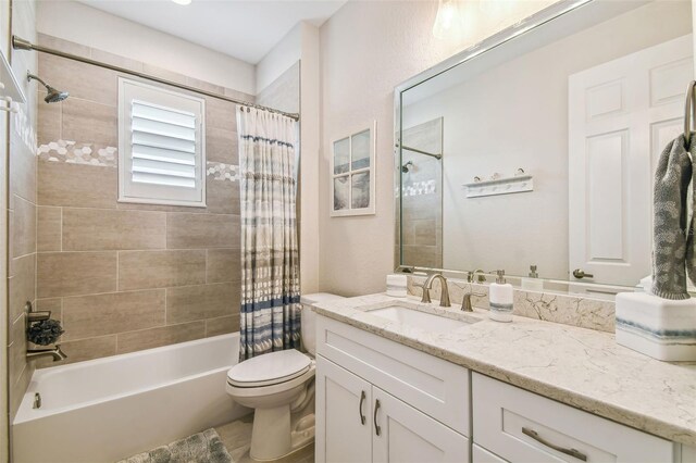 full bathroom with vanity, shower / tub combo, and toilet