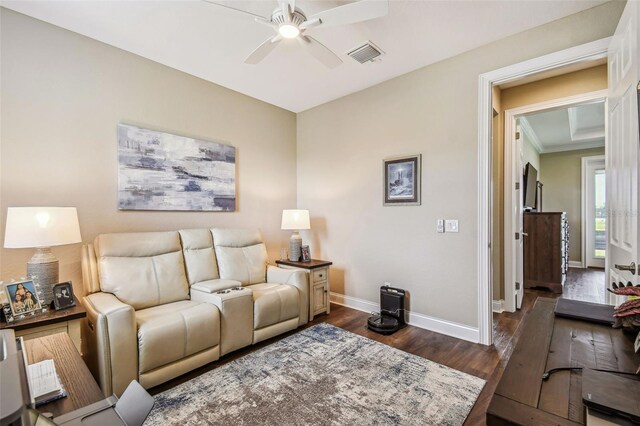 living room featuring ceiling fan and dark hardwood / wood-style floors