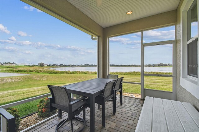 sunroom featuring plenty of natural light and a water view