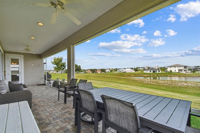 view of patio / terrace with ceiling fan and a water view