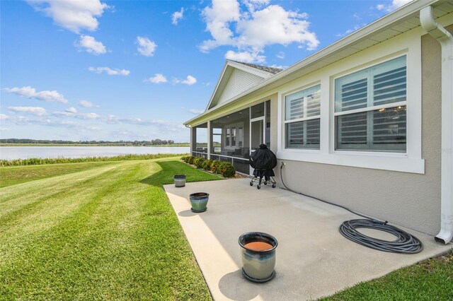 view of patio featuring a sunroom, a water view, and grilling area